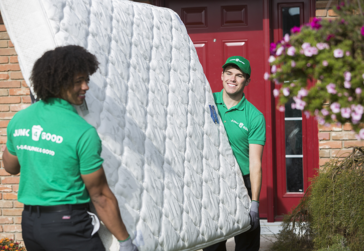 Men carrying a mattress out of a home