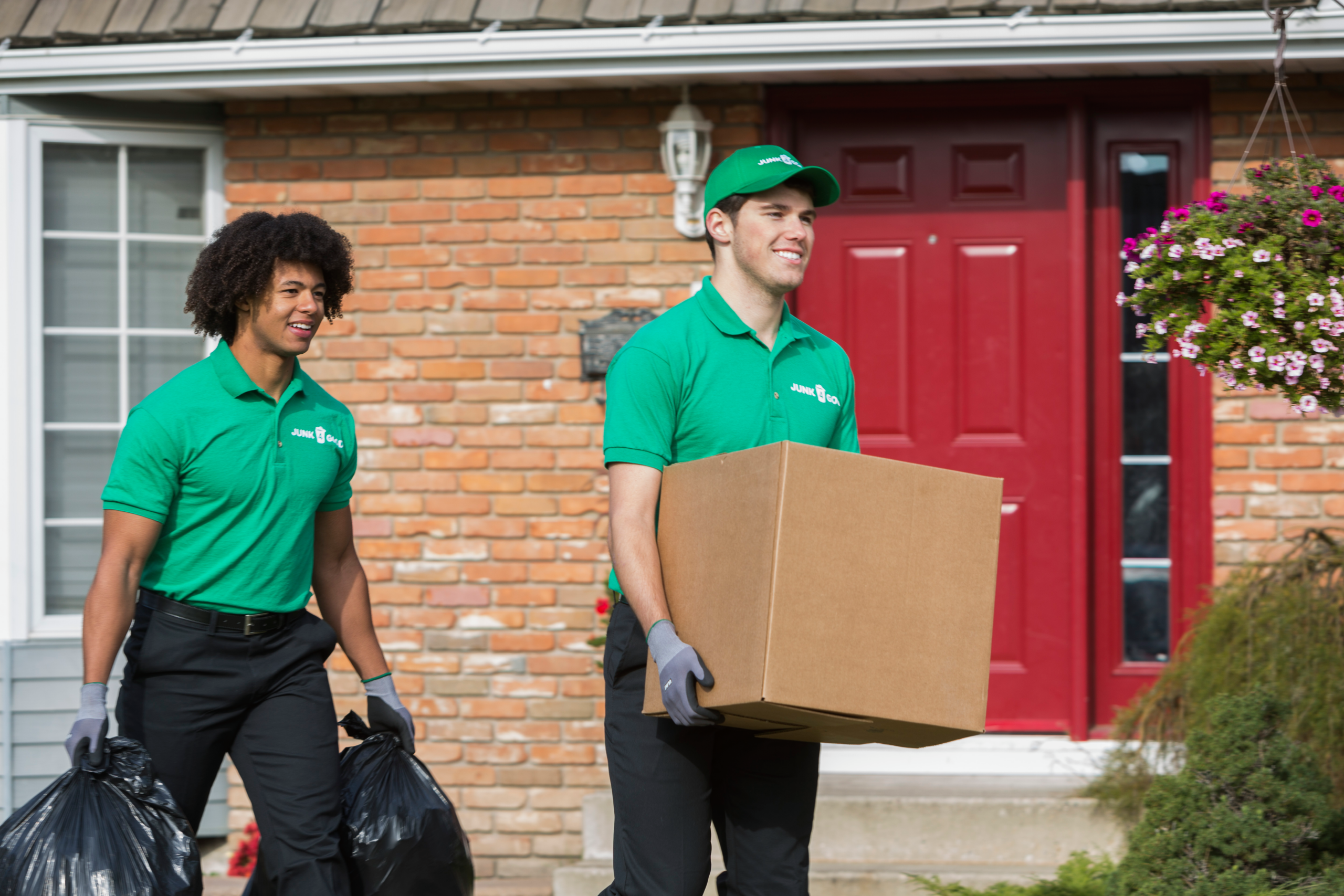 Junk removal staff take items out of customers home.