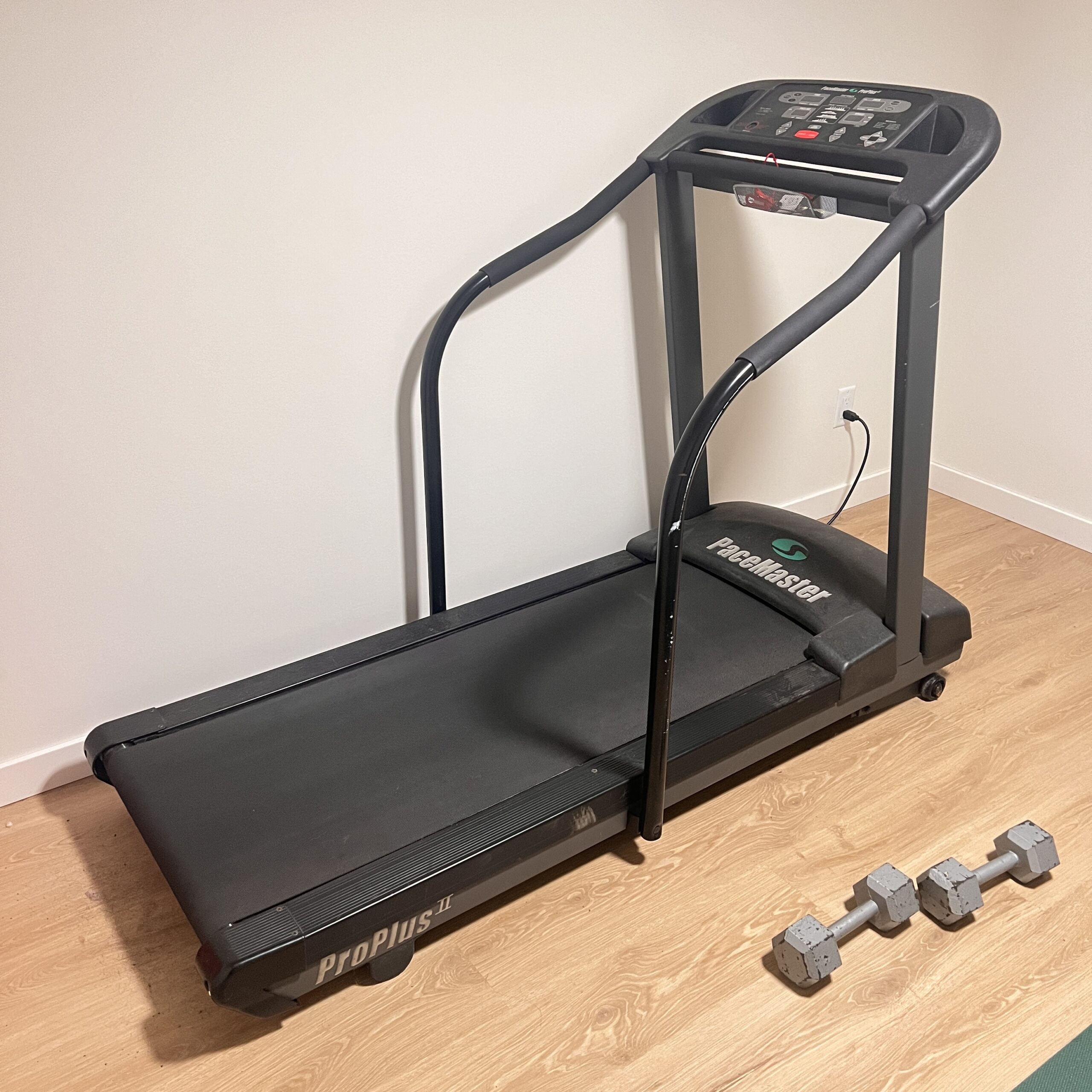 Old, broken down treadmill in a home gym, ready for exercise equipment removal and recycling.